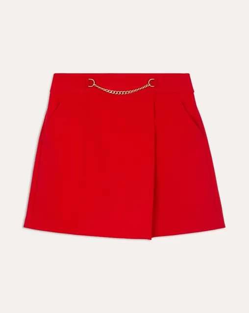 Falda roja con cadena dorada en la cintura